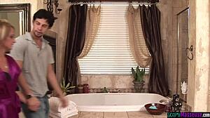 Kaunis tyttö vetää kyrpää höyryisessä suihkuhieronnassa ruskean hierojan kanssa