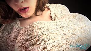 彼女のタイトなセーターを伸ばすのを見て圧倒される