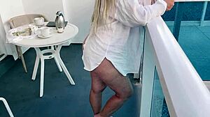 Blonde big tit babe teases pussy on public hotel balcony
