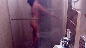 In the shower, she fingers her pussy, embracing her slutty nature with big tits.