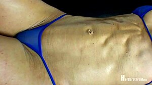 Bailey flexes her muscular body in a bikini and thong at the beach.