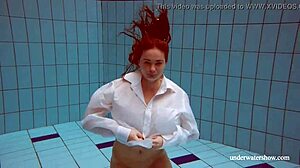 Redhead Lola swims nude in the pool with friends