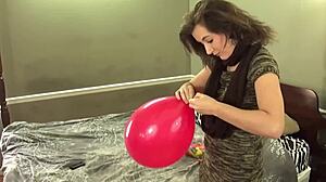 brunette in stockings blows balloons while chewing gum, so sexy