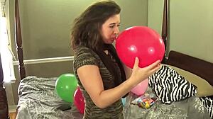 brunette in stockings blows balloons while chewing gum, so sexy