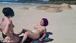 Two lesbians stripped bare on the beach, locking lips.