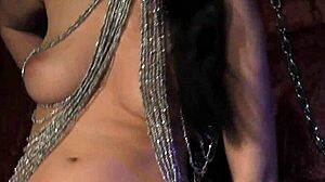 Glamcore domina uses dildo to tease bound pussy in bdsm.