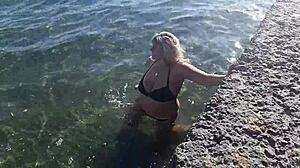 Milf playing with her candy body on public beach.