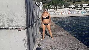 Milf playing with her candy body on public beach.