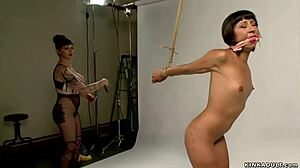 Butt plugged lesbian gets whipped in submission bondage