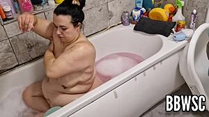 Amateur video of a chubby woman washing her big breasts in the bathtub