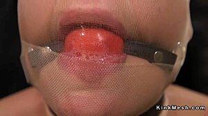 Brunette slave endures kinky punishment with hose covering her face in bizarre bondage.