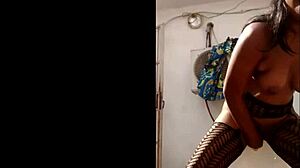 Masked ebony woman fucks herself with a big dildo outside her house in a voyeur webcam session.