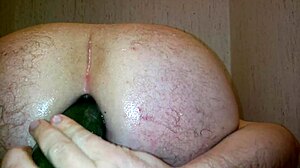 Gay guy uses vegetable in shower sex scene.