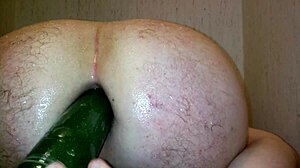 Gay guy uses vegetable in shower sex scene.