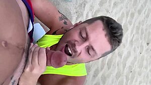 guy gives blowjob to another on public gay beach