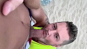 guy gives blowjob to another on public gay beach