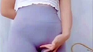 the young asian girl dances in the room, showing off her cameltoe