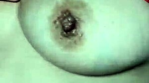 A mature wife showcases her breasts in an intimate, sensual scene