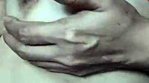 A mature wife showcases her breasts in an intimate, sensual scene