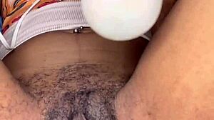 Horny slut edges her ebony hairy pussy with tongue piercing in close-up