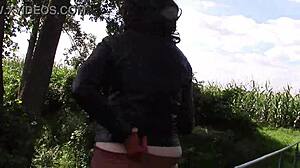 She smokes while wearing cinnamon leather trousers outdoors.