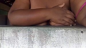 This naughty believer is showing her big tits to guys on the street from the window